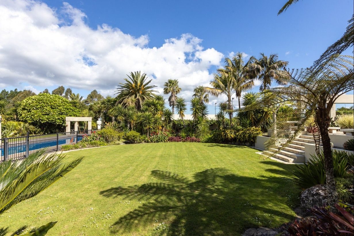 The sheltered lawn running between the pool and the gardens